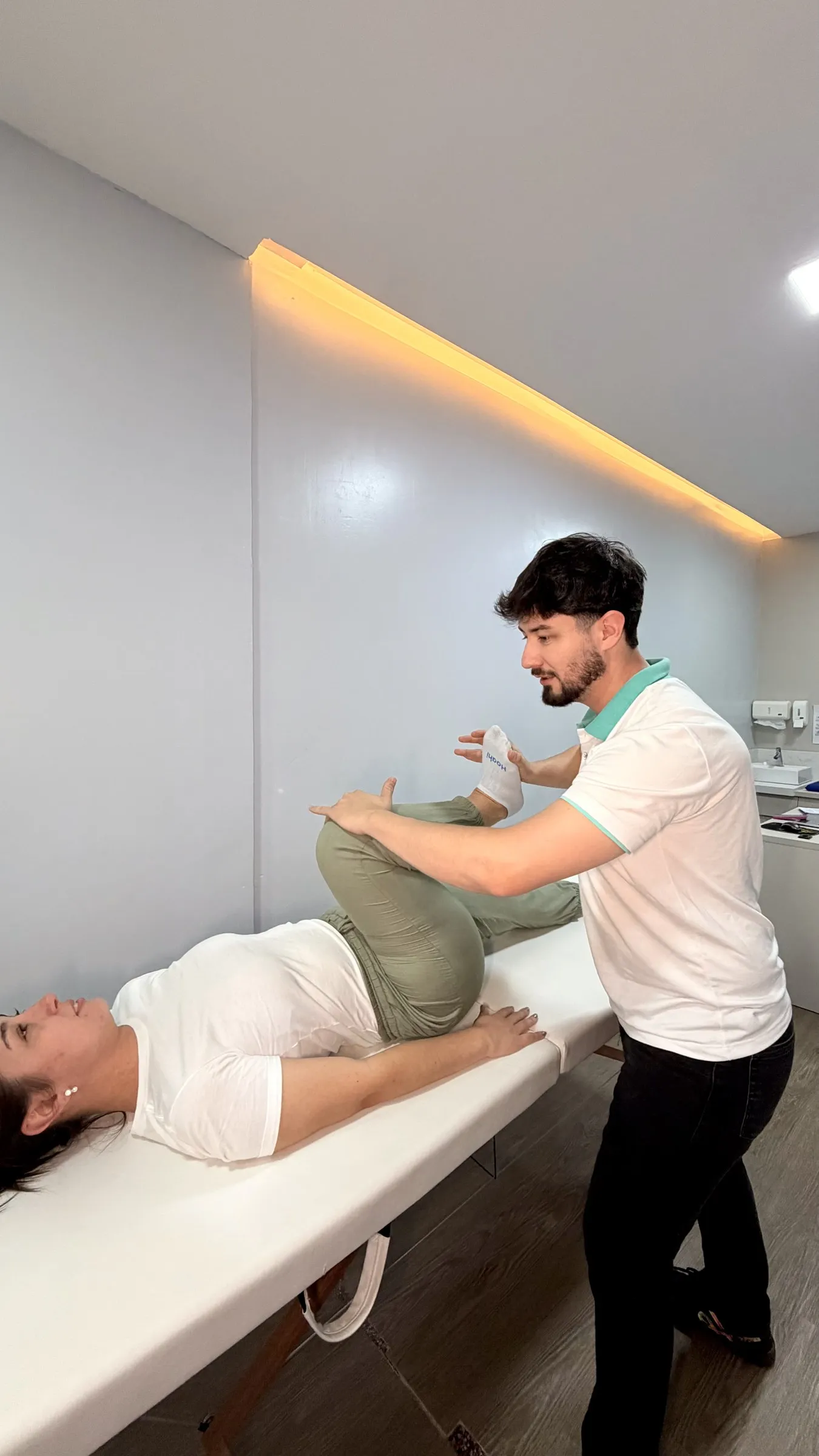 Fisioterapeuta conduzindo exercícios com paciente no espaço de fisioterapia da sede